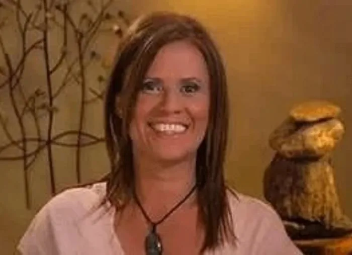 Isa Herrera smiling during a television interview, seated against a warm gold studio background.